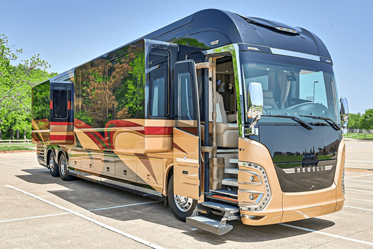luxury-coaches A large, modern luxury motorhome with an extended slide out and open door sits in an empty lot on a sunny day, showcasing its spacious design Specialized RV Repair and Conversions, Inc